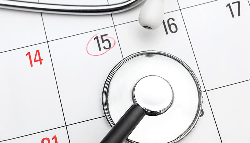 Stethoscope on calendar with marked date. Medical examination concept.