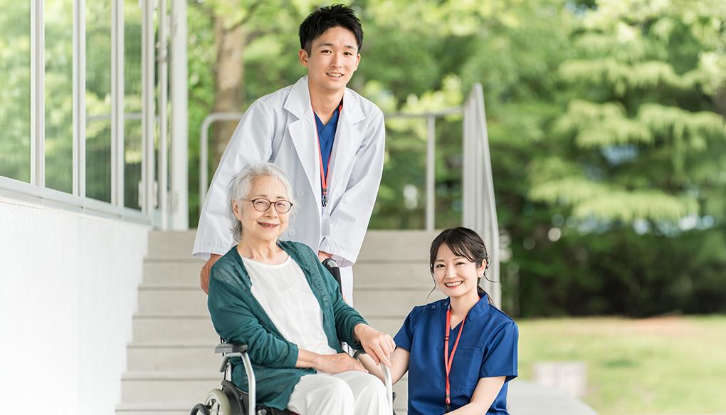 コミュニティホスピタルで笑顔の高齢患者を出迎える若い男女の医師